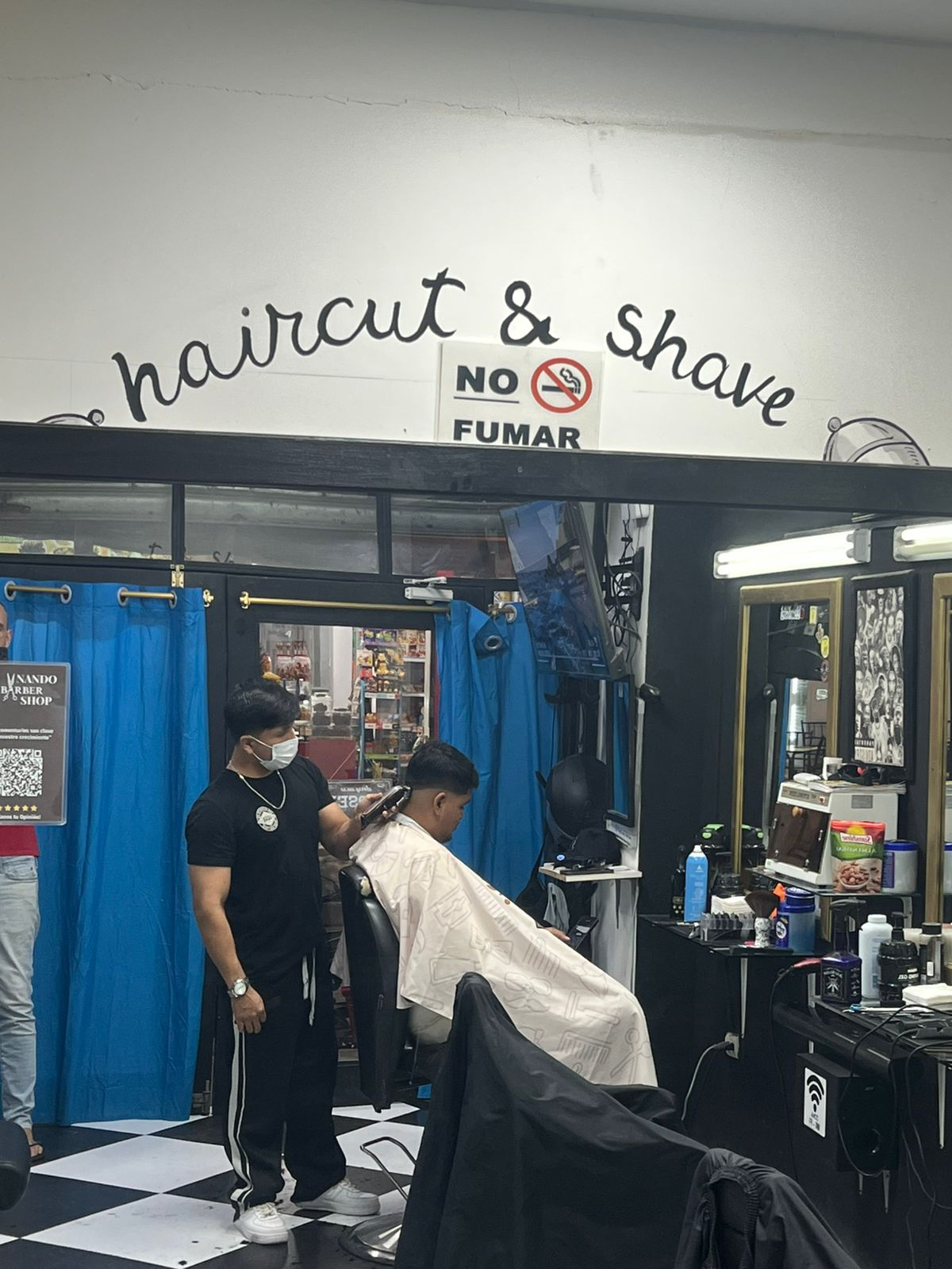 Nando cortando el cabello en su barbería de Montañita